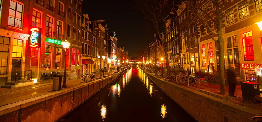 Vue nocturne du Quartier Rouge d’Amsterdam, connu pour ses boutiques spécialisées et ses vitrines colorées